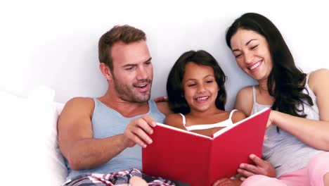 Nette-Familie,-Die-Ein-Buch-Auf-Ihrem-Bett-Liest
