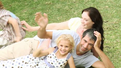 Happy-family-on-the-grass-waving-at-the-camera