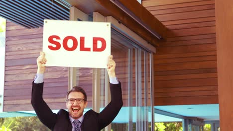 Estate-agent-cheering-and-holding-SOLD-sign