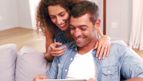 Cute-happy-couple-using-tablet-on-the-couch