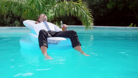 Businessman-lying-on-lilo-in-swimming-pool