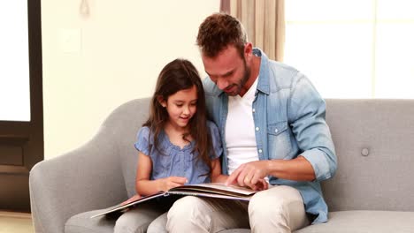 Happy-father-and-daughter-reading-a-book