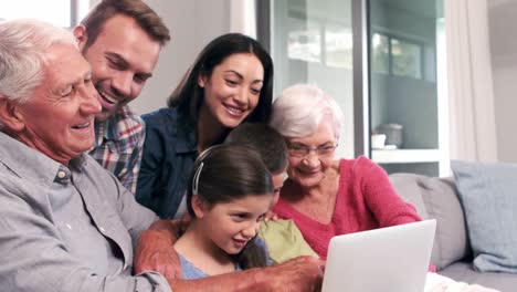 Niedliche-Mehrgenerationenfamilie-Mit-Laptop-Auf-Der-Couch