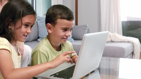 Cute-siblings-using-laptop-in-the-living-room