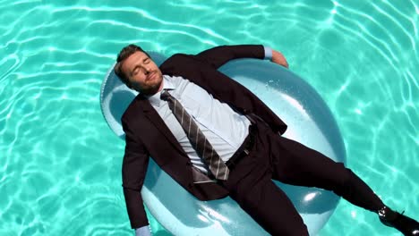 Businessman-relaxing-on-buoy-