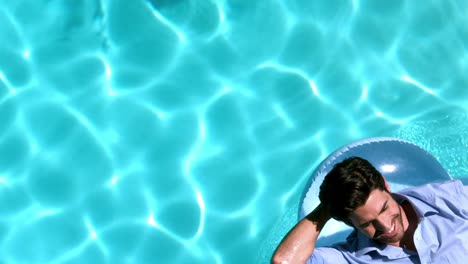 Businessman-lying-on-buoy-in-swimming-pool