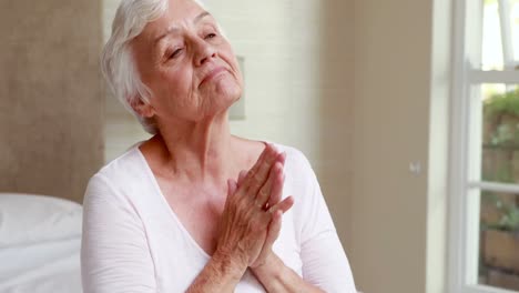 Senior-woman-praying-in-bed