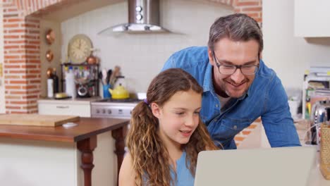 Smiling-father-and-daughter-using-laptop