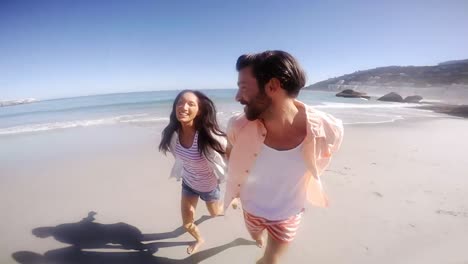 Young-couple-running-on-beach