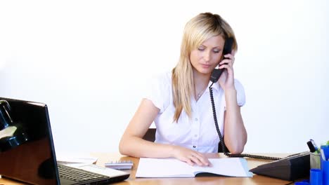 Mujer-De-Negocios-Hablando-Por-Teléfono-Y-Leyendo-Informes-En-La-Oficina