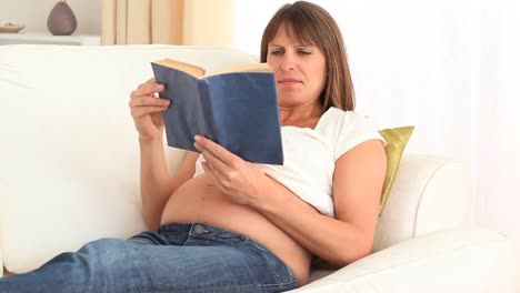Mujer-Embarazada-Enfocada-Leyendo-Un-Libro