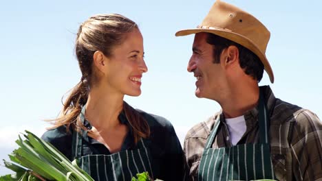Smiling-couple-holding-a-beetroot-in-field