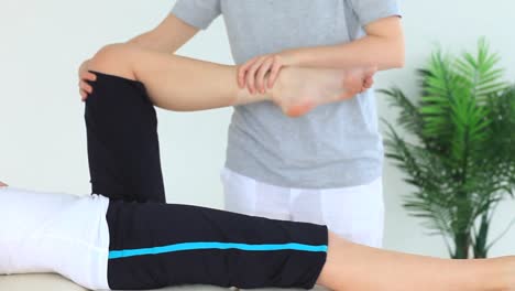 Woman-doing-some-exercises-helped-by-a-physiotherapist