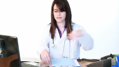 Brünette-Ärztin-Telefoniert-Und-Benutzt-Einen-Laptop-Im-Büro