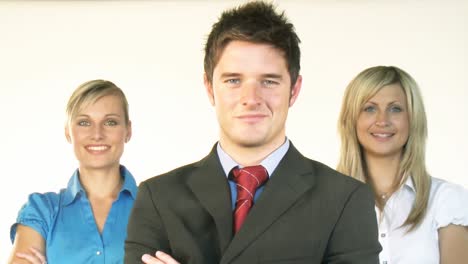 Confident-businessman-with-businesswomen-in-the-background