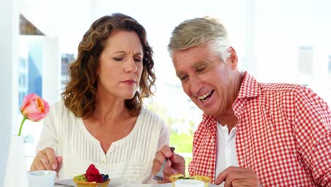 Smiling-mature-couple-interacting-while-having-breakfast