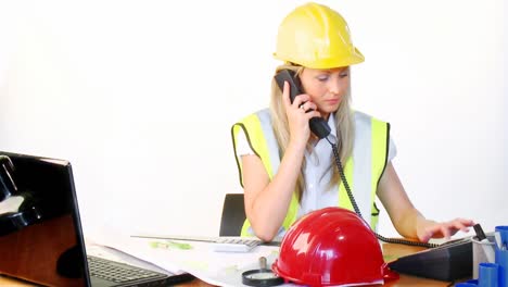 Female-architect-on-phone-and-using-a-laptop