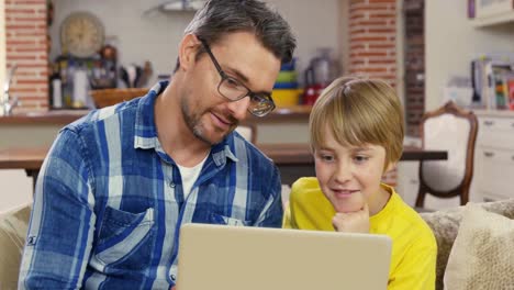 Smiling-father-and-son-using-laptop