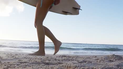 Woman-walking-with-surfboard