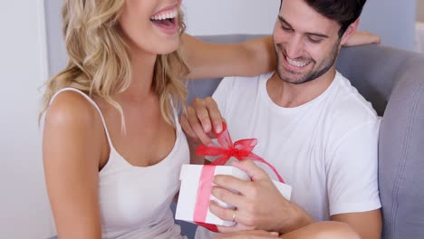 Man-opening-a-gift-he-just-received