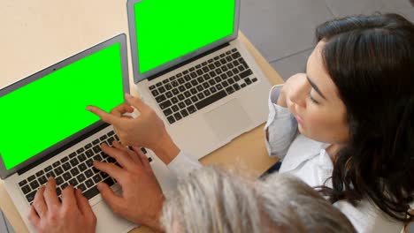 Frau-Und-Geschäftsmann-Interagieren-Miteinander,-Während-Sie-Einen-Laptop-Benutzen