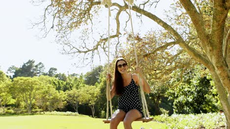 Young-woman-swinging-on-swing-in-park