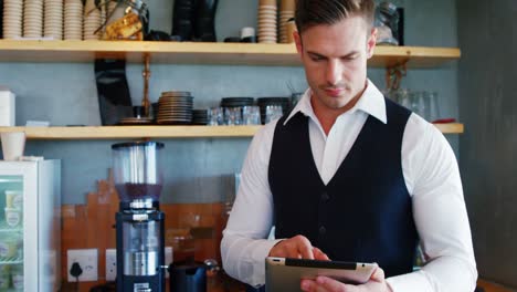 Waiter-using-digital-tablet-in-restaurant