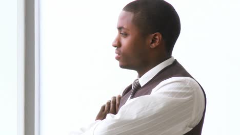Thoughtful-AfroAmerican-businessman-with-folded-arms-in-office