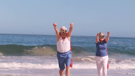 senior-couple-making-superheros-on-the-beach
