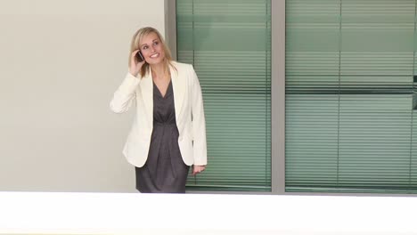 Young-businesswoman-talking-on-phone-in-workplace