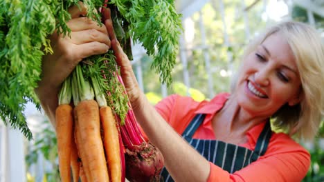 Mature-woman-holding-bunch-of-vegetables
