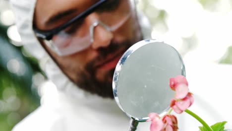 Man-examining-plant-through-magnifying-glass