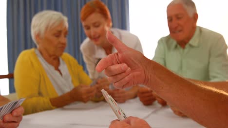 Doctor-watching-senior-people-playing-cards