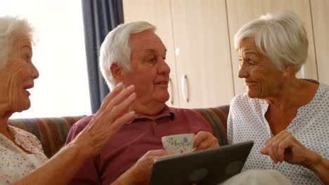 Senior-friends-discussing-together-with-a-digital-tablet