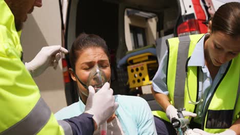 Patient-receiving-oxygen-mask-from-ambulance-team