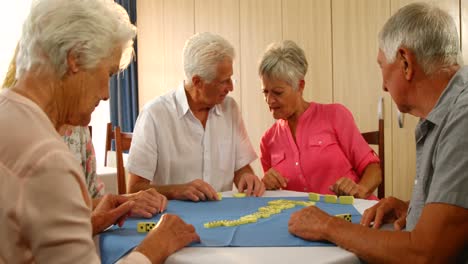 Ältere-Freunde-Unterhalten-Sich-Beim-Dominospielen