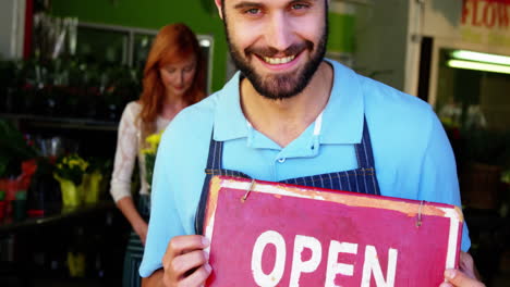 Male-florist-holding-open-signboard