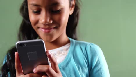 Schoolgirl-using-mobile-phone-in-classroom-at-school