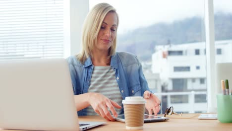 Businesswoman-using-digital-tablet-at-her-desk