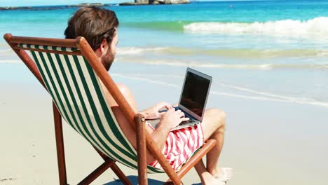 Hombre-Usando-Laptop-En-La-Playa