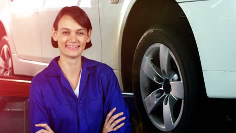 Female-mechanic-checking-a-wheel-and-smiling-at-camera