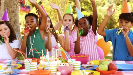 Gruppe-Von-Kindern-Bläst-Partyhupe,-Während-Sie-Einen-Geburtstag-Feiern