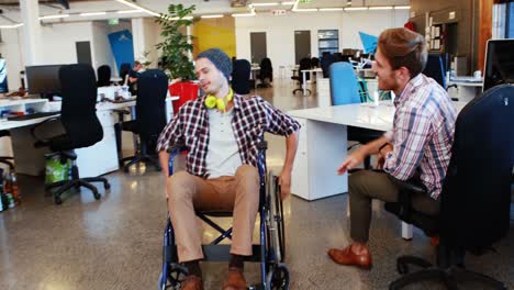 Businessman-in-wheelchair-giving-high-five-to-coworkers