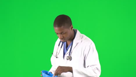 Footage-of-an-ethnic-male-doctor-examining-pills-with-forceps