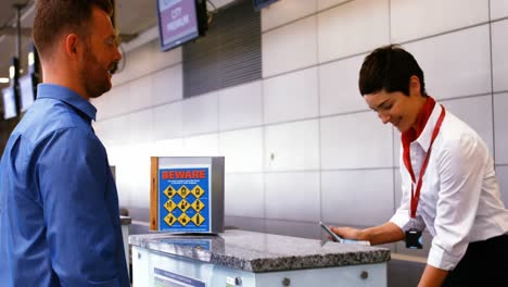 Weibliches-Flughafenpersonal-überprüft-Reisepass-Und-Interagiert-Mit-Mann-Am-Check-in-Schalter