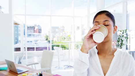 Frau-Nippt-An-Kaffee-Mit-Bürohintergrund