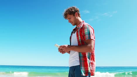 Man-talking-on-mobile-phone-at-beach