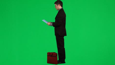 Businessman-reading-a-report-against-green-screen-footage