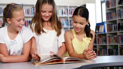 Niños-De-La-Escuela-Leyendo-Un-Libro-Juntos-En-La-Biblioteca