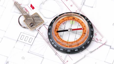 Close-up-of-plans,-compass-and-keys-turning
